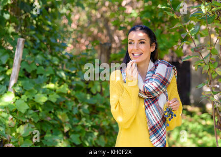 Eine schöne Frau genießen die Ernte der Weintrauben während eines warmen Herbst auf die Landschaft. Stockfoto