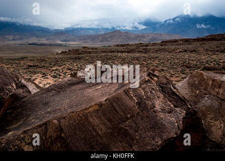 Sky Rock, einen Blick gen Himmel Serie von petroglyphen von der Paiute-Shoshone Inder vor Tausenden von Jahren links, sitzt, bevor die Berge der Sierra Nevada. Stockfoto