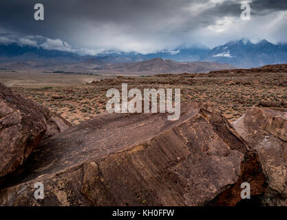 Sky Rock, einen Blick gen Himmel Serie von petroglyphen von der Paiute-Shoshone Inder vor Tausenden von Jahren links, sitzt, bevor die Berge der Sierra Nevada. Stockfoto