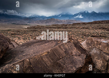 Sky Rock, einen Blick gen Himmel Serie von petroglyphen von der Paiute-Shoshone Inder vor Tausenden von Jahren links, sitzt, bevor die Berge der Sierra Nevada. Stockfoto