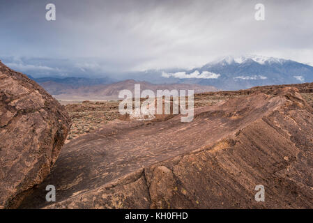 Sky Rock, einen Blick gen Himmel Serie von petroglyphen von der Paiute-Shoshone Inder vor Tausenden von Jahren links, sitzt, bevor die Berge der Sierra Nevada. Stockfoto