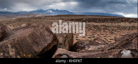 Sky Rock, einen Blick gen Himmel Serie von petroglyphen von der Paiute-Shoshone Inder vor Tausenden von Jahren links, sitzt, bevor die Berge der Sierra Nevada. Stockfoto