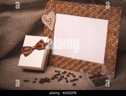 Desktop Bilderrahmen und Kaffeebohnen mit Geschenkbox auf Leinen Stockfoto