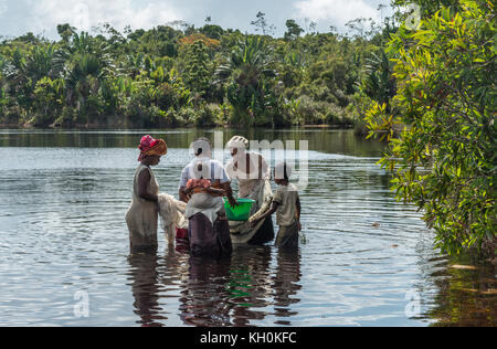 Mehrere Frauen mit Kindern Madagaskars fischen in einem See. Madagaskar, Afrika. Stockfoto