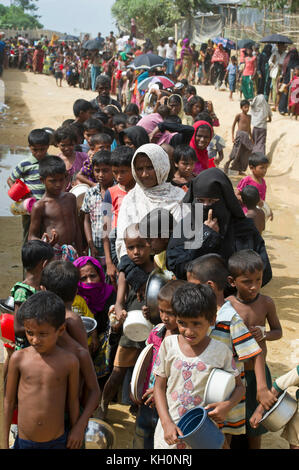 Bangladesch. November 2017. Rohingya-Flüchtlinge, die meisten von ihnen Frauen und Kinder, bilden mit ihren Schüsseln eine sehr lange Schlange in Erwartung einer Lebensmittelverteilung in einem der Flüchtlingslager in Bangladesch entlang der Grenze zu Myanmar. Der Zustrom von Flüchtlingen hat sich von seinem Höhepunkt verlangsamt, aber Schätzungen gehen davon aus, dass die Zahl der Menschen, die die Grenze jeden Tag überqueren, immer noch zwischen zwei und dreitausend liegt. (ALAMY LIVE NEWS/Chuck Bigger/Nov. Kredit: Chuck Bigger/Alamy Live Nachrichten Stockfoto
