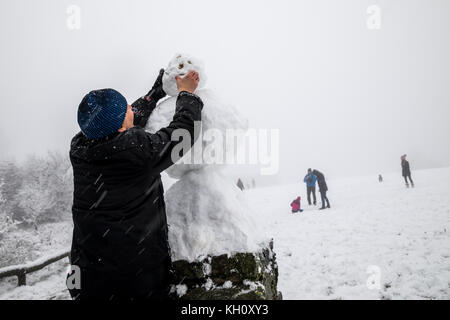 Schmitten, Deutschland. November 2017. Ein Mann errichtet am 12. November 2017 in Schmitten einen Schneemann auf dem schneebedeckten Taunus. Auf dem Gipfel des Hochlands sind heute etwa 10 Zentimenter Schnee gefallen. Quelle: Jan Eifert/dpa/Alamy Live News Stockfoto