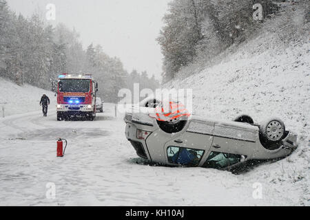 Hahnbach, Deutschland. November 2017. Ein Auto liegt nach einem Unfall auf der schneebedeckten Autobahn 14 bei Hahnbach am 12. November 2017 verkehrt herum. Das Fahrzeug hatte zwei Passagiere, die von Hahnbach nach Gebenbach fuhren. Der 64-jährige Fahrer und der 79-jährige Beifahrer gaben an, mit einer Geschwindigkeit von 60 km/h auf der schneebedeckten Autobahn zu fahren, als das Auto zu schleudern begann und mit einem Umkippen des Fahrzeugs endete. Beide Passagiere hatten leichte Verletzungen und wurden vorsorglich ins nächste Krankenhaus gebracht. Quelle: Jürgen Masching/-/dpa/Alamy Live News Stockfoto