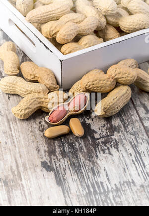 Erdnüsse in Schalen auf Holz Hintergrund mit selectiv Fokus Stockfoto