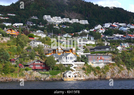 Häuser gruppierten an der Westküste der Åsane Stadt Bergen, Norwegen, mit Veten Berg hinter. Stockfoto