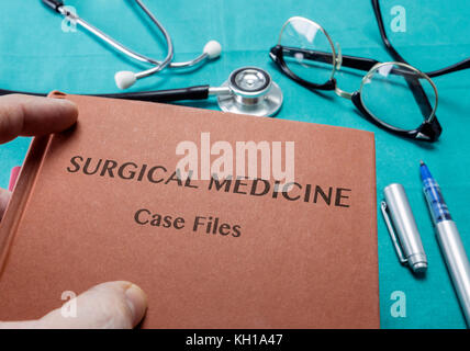 Arzt hält Buch auf der chirurgischen Medizin eines Krankenhauses Stockfoto