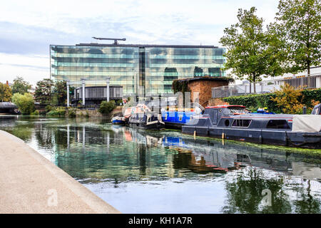 Narrowboats günstig auf den Regent's Canal in King's Cross, London, UK, die Glasfassade des Gebäudes des Königs im Hintergrund, 2017 Stockfoto