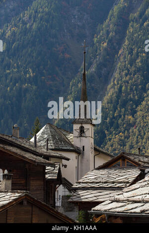 BLATTEN, SCHWEIZ - SEPT. 28, 2017: altes Bergdorf mit der weißen Kirche durch traditionelle Holzchalets mit flachen Stein Dächer umgeben. Stockfoto