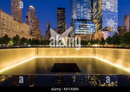Im Norden einen reflektierenden Pool bei Dämmerung mit Blick auf das World Trade Center Tower 3 und 4 und die Oculus beleuchtet. Lower Manhattan, New York City