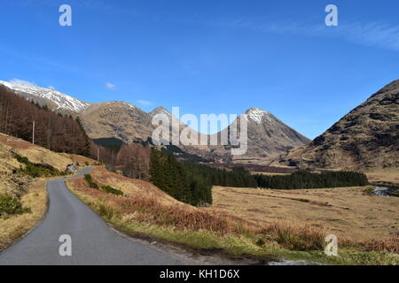 Buachaille Etive Beag und Buachaille Etive Mor U-förmiges Tal an einem sonnigen Tag in Glencoe, von der Straße in Glen Etive eingenommen Stockfoto