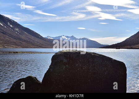 Loch Etive hinunter in Richtung Cruachan und die umliegenden Berge, mit Vordergrund Boulder am Ufer. Glen Etive, Schottland. Stockfoto