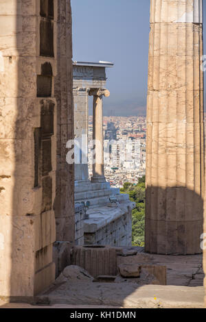 Blick durch Marmorsäulen des Parthenon durch die propyläen Eingangstor und bis in die moderne Stadt Athen Stockfoto