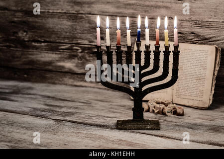 Menorah mit Kerzen für Chanukka gegen defokussierten Lichter, Nahaufnahme Stockfoto