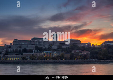 Budapest, Ungarn - Dramatischer Sonnenuntergang und farbenfroher Himmel und Wolken über dem berühmten Königspalast der Buda-Burg Stockfoto