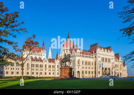 Budapest, Ungarn - Das ungarische Parlament am frühen Morgen mit der Pferdestatue von Ferenc Rakoczi. Klarer blauer Himmel Stockfoto