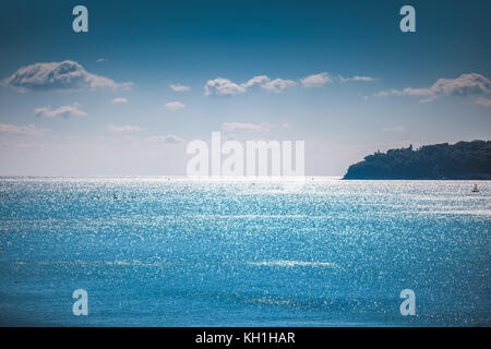 Blaue Meer mit glänzenden Wellen und Wolken am Himmel Stockfoto
