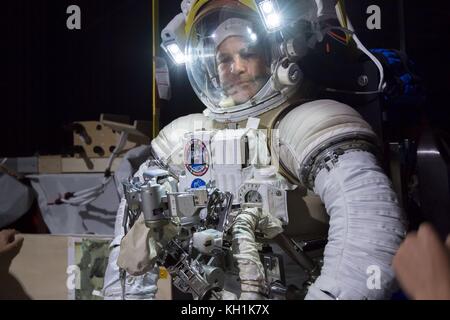 Jeremy Hansen, Astronaut der kanadischen Raumfahrtbehörde, wird während einer Simulation der Schwerelosigkeit im Active Response Gravity Offload System im Johnson Space Center am 30. Oktober 2017 in Houston, Texas, über einem Modell der Internationalen Raumstation aufgehängt. Stockfoto