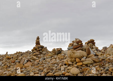 Mann aus Stapeln von Stein/Cairns - Futter das East Beach der heiligen Insel Stockfoto