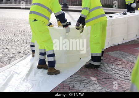 Katastrophenschutz Männer mit hoher Sichtbarkeit Kleidung während einer Übung Hochwasser in der Stadt zu verhindern. Stockfoto