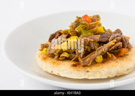 Die traditionelle kolumbianische Arepa gekrönt mit zerkleinertem Rindfleisch Stockfoto