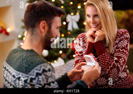 Happy girl Überraschungen Mann mit Schwangerschaft Test in Weihnachtsgeschenk Stockfoto