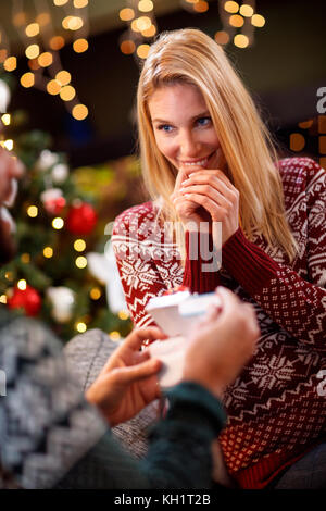 Junge Frau überraschung Männer mit positiven Schwangerschaftstest für Weihnachten Geschenk Stockfoto