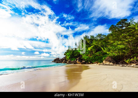 Sonnigen Tag am Paradise Beach mit großen Granitfelsen, türkisfarbenes Wasser, weißer Sand und Palmen an der Anse Georgette, Praslin Seychellen Stockfoto