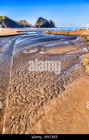 Texturierte sand in einem Bachbett bei Ebbe, Piha Beach, Region Auckland, Neuseeland. Stockfoto