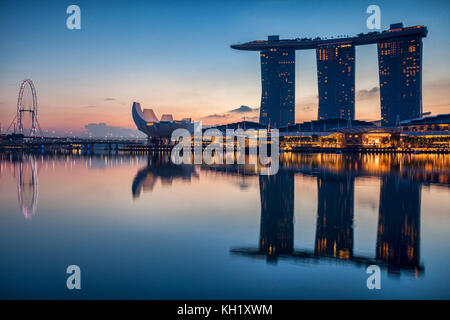 Skyline von Singapur mit Marina Bay Sands, Kunst- und Wissenschaftsmuseum und Singapore Flyer spiegeln sich im Hafen wider. Stockfoto