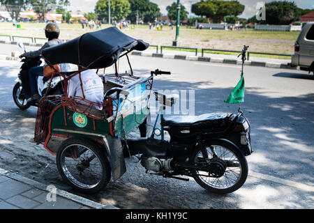 Yogyakarta - Oktober 2017: traditionelle Rikscha Transport auf Straßen von Yogyakarta, Java, Indonesien. Fahrrad Rikscha bleibt beliebtes Verkehrsmittel Stockfoto