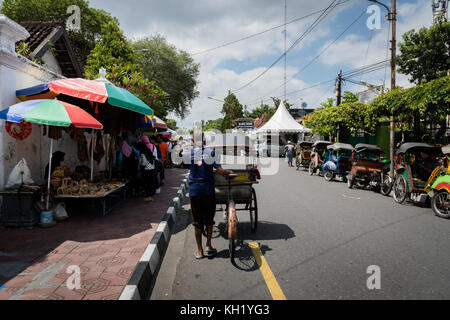 Yogyakarta - Oktober 2017: traditionelle Rikscha Transport auf Straßen von Yogyakarta, Java, Indonesien. Fahrrad Rikscha bleibt beliebtes Verkehrsmittel Stockfoto