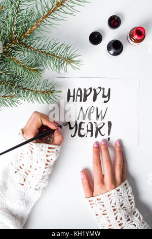 Mädchen schreiben Frohes neues Jahr Kalligraphie Karte Ansicht von oben Stockfoto