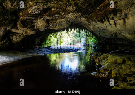 Frau genießen die atemberaubende Moria Gate Arch im Oparara Basin, karamea, Südinsel, Neuseeland Stockfoto