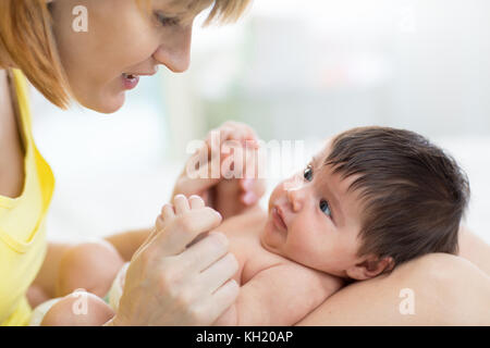 Seitenansicht der schönen Mutter und ihrem Säugling Baby an einander, Zeit, gemeinsam zu Hause Stockfoto