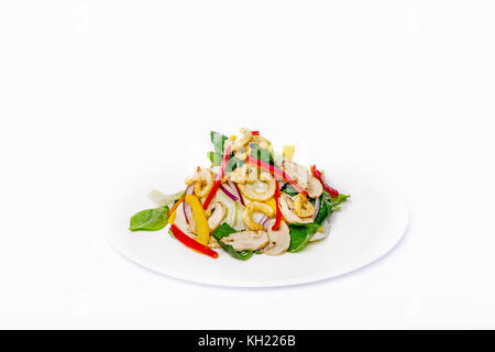 Pan-Asiatischer Salat, Gemüse mit frittierte Tintenfischringe. auf einem weißen Teller auf einem weißen Hintergrund. Stockfoto