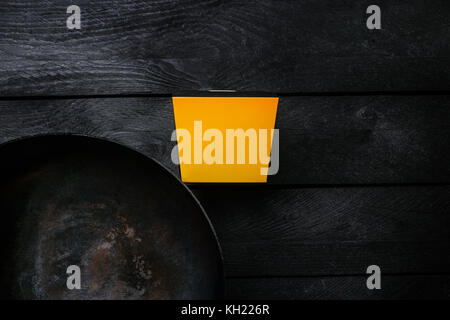 Asiatischer wok - traditionelle orientalische Pan auf schwarzem Holz Hintergrund. Mit einer Box für Nudeln. nach oben anzeigen. Stockfoto