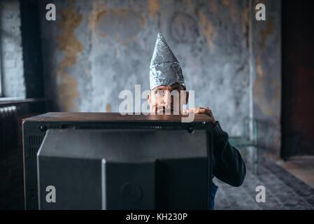 Angst Mann in Aluminiumfolie cap Watch tv, Ufo Stockfoto