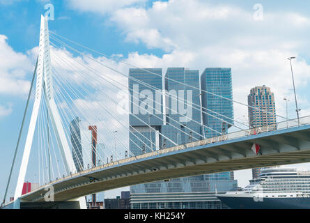 Passagierschiff günstig unter sanft geschwungene Form der Erasmus Brücke, mit architektonisch modernen De Rotterdam überragt in Rotterdam, Holland. Stockfoto