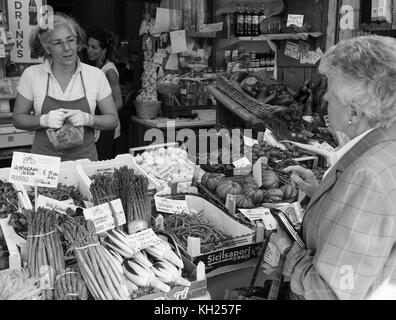 Zwei Frauen unterhalten sich auf einem Markt, wo frische Lebensmittel verkauft wird, in Venedig, Italien Stockfoto