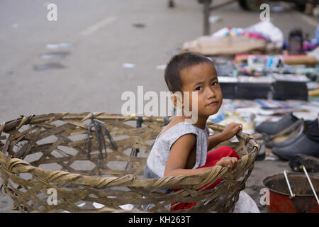 Ein Filipino Junge in einem Korb sitzen, in der Innenstadt von Cebu City, Philippinen Stockfoto