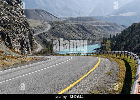 Malerischer herbst Blick auf den gewundenen Asphaltstraße entlang den Fluss, die Berge und den Fluss mit türkisfarbenem Wasser Stockfoto