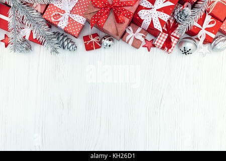 Weihnachten rot Geschenkboxen, Tannenbaum, Zweige und Silber Dekorationen auf Holz Hintergrund der Ansicht von oben Stockfoto