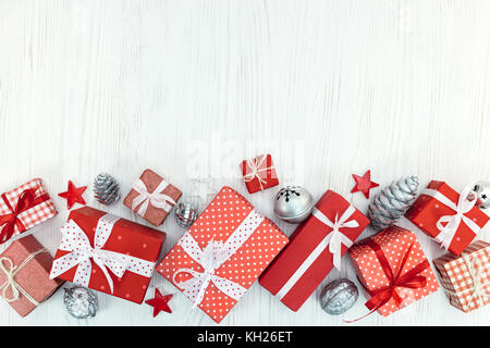 Geschenkboxen in rot Papier gewickelt, Weihnachtsschmuck auf weissem Holztisch Hintergrund Stockfoto