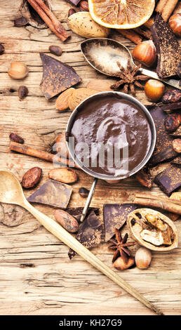 Schale mit geschmolzener Schokolade, Kakao, Nüssen und Gewürzen Stockfoto