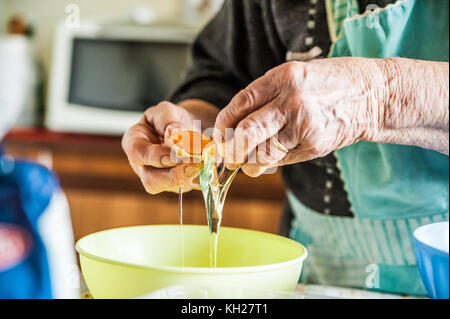 Hände von italienischen Grandma holding Ei während der Pasta Stockfoto