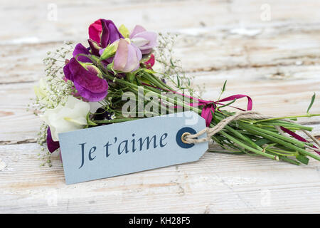 Kleinen Blumenstrauß mit Wicken und Grußkarte mit französischen Text: Ich liebe dich Stockfoto
